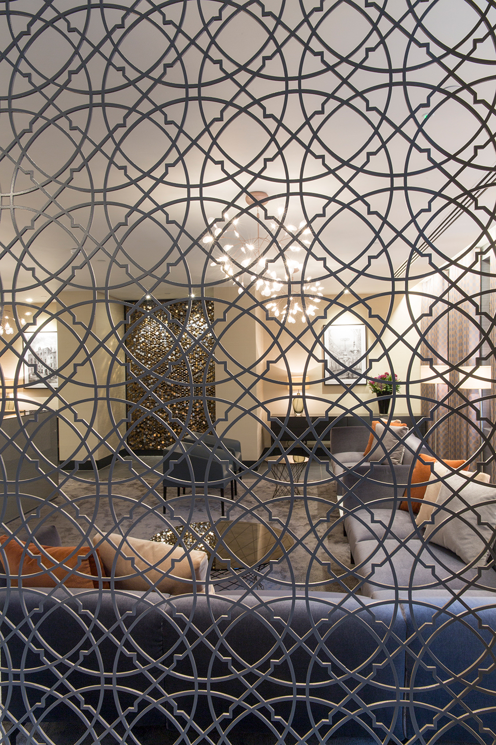Plush Mayfair reception and waiting area design - view through feature metalwork panel