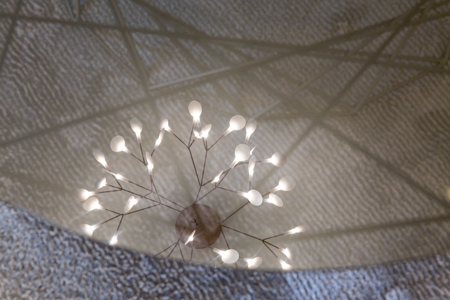 Plush Mayfair reception and waiting area design - relection of feature Moooi pendant light in coffee table